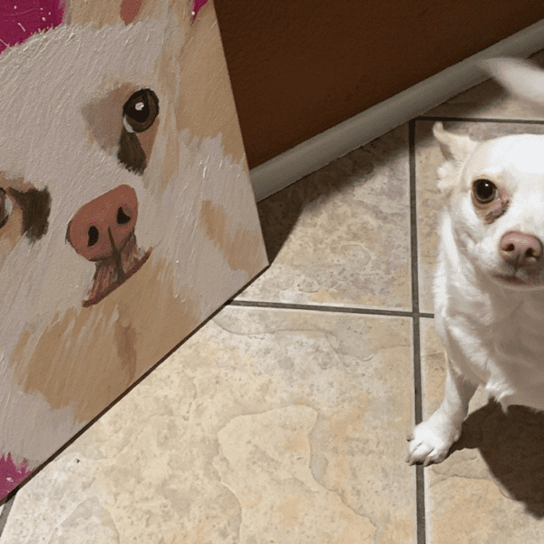 Dog standing next to a painting of itself and looking up
