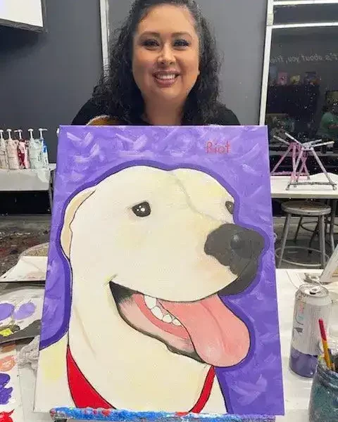Staff picture holding dog painting