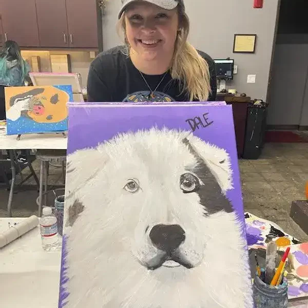 Staff holding painting of dog