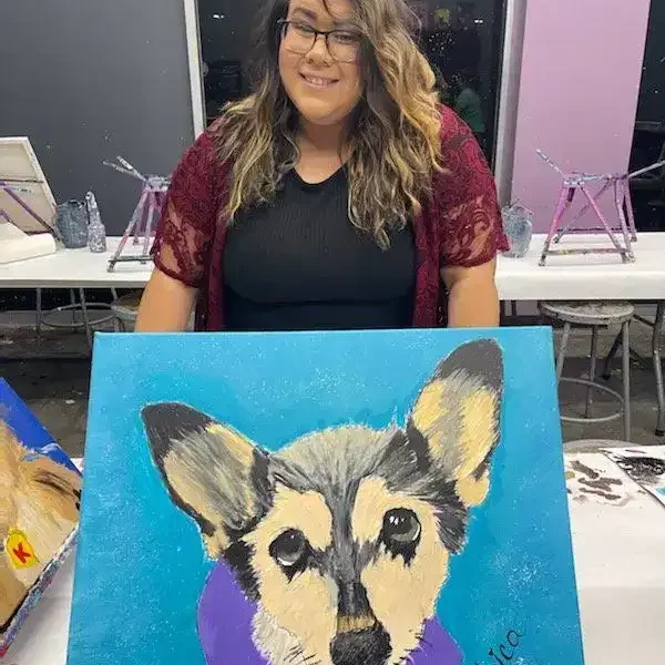 Staff picture holding painting of dog